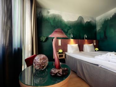 Ett grönt skogslikt rum på Kosta Boda Art Hotel
